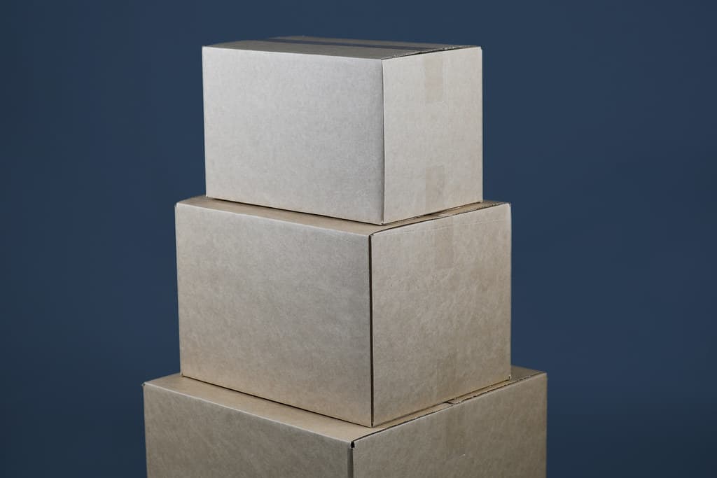 Three taped cardboard boxes stacked on top of each other